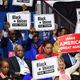 Herman Cain, left center, and supporters of “Black Voices for Trump” listen to him speak during a campaign rally at the BOK Center on June 20, 2020, in Tulsa, Oklahoma.